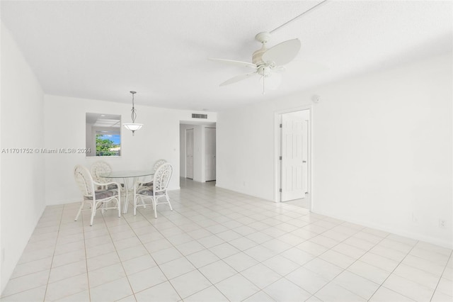 unfurnished dining area with ceiling fan and light tile patterned flooring