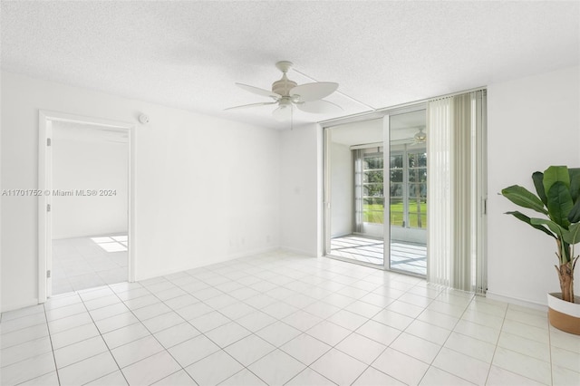 unfurnished room featuring ceiling fan, light tile patterned floors, and a textured ceiling