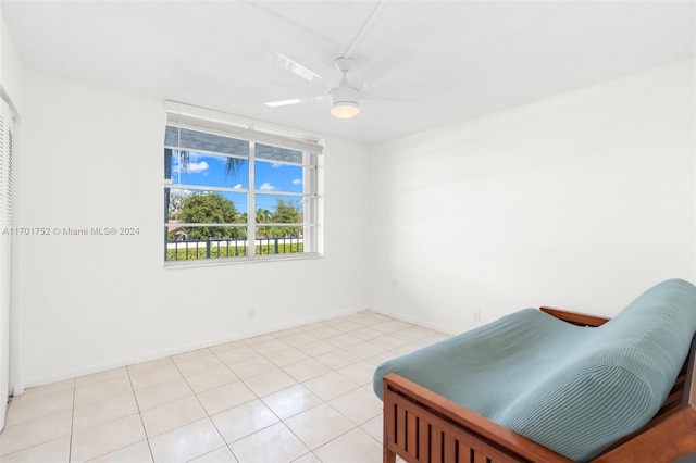 living area featuring light tile patterned floors and ceiling fan