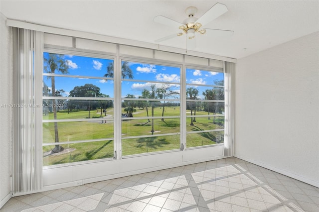 unfurnished sunroom with ceiling fan