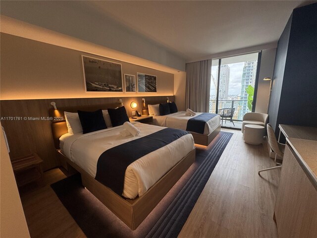 bedroom with light hardwood / wood-style flooring and expansive windows