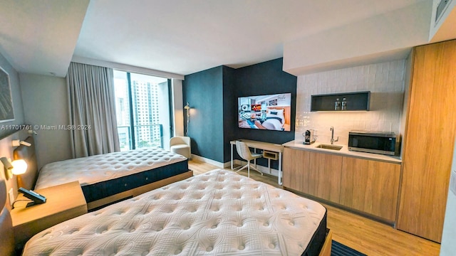 bedroom with light wood-type flooring and sink