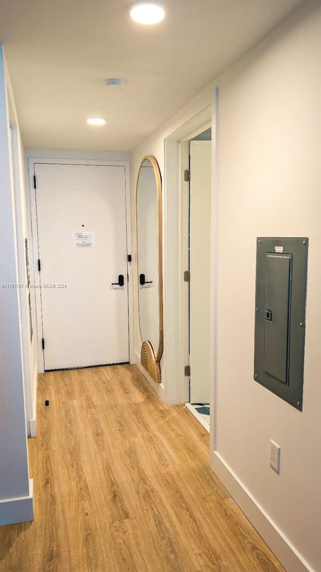 hallway with electric panel and light hardwood / wood-style flooring