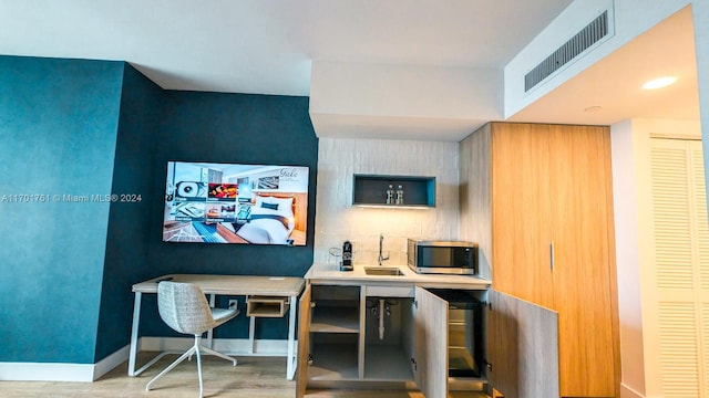 office featuring light hardwood / wood-style floors and sink