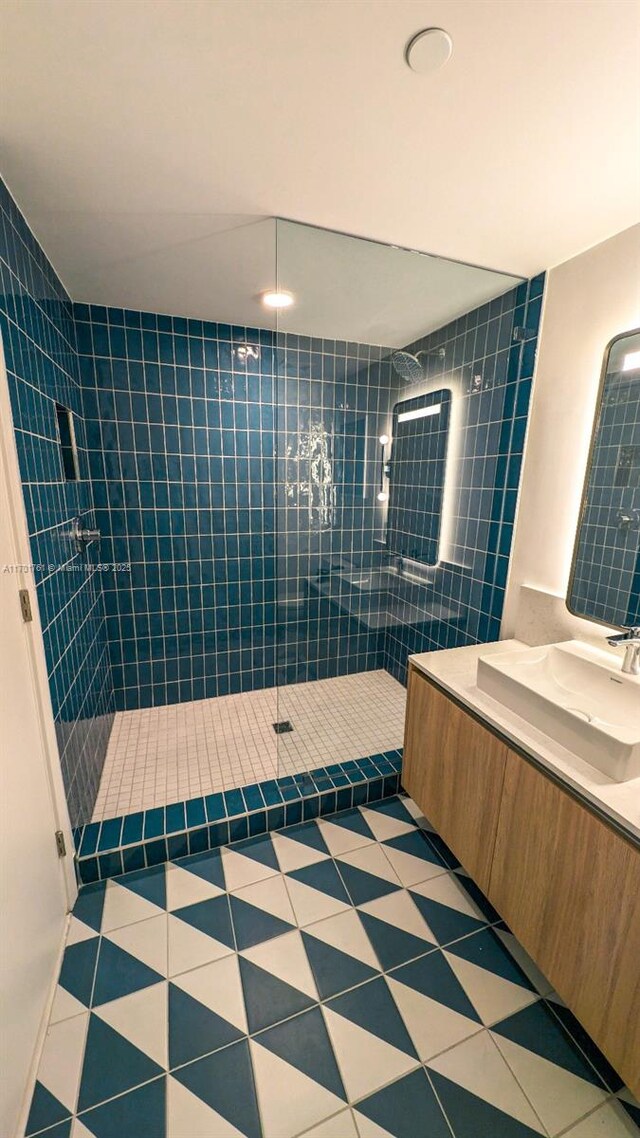 bathroom featuring tile patterned floors, vanity, and a tile shower