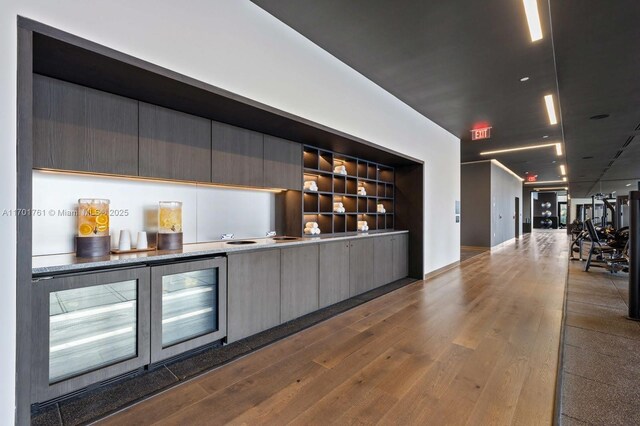 bar with gray cabinetry, hardwood / wood-style flooring, and built in shelves