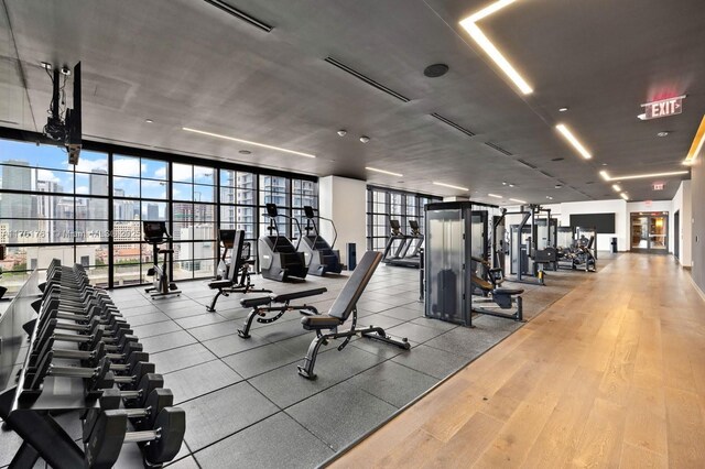 gym with a wall of windows and hardwood / wood-style floors