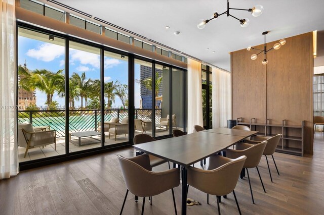 dining area with expansive windows, a chandelier, and hardwood / wood-style floors