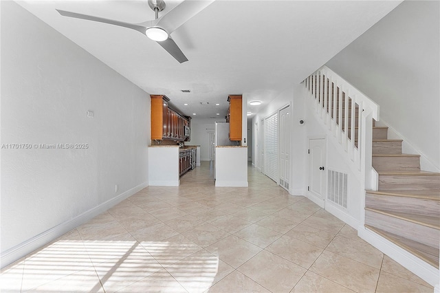 unfurnished living room with ceiling fan and light tile patterned floors