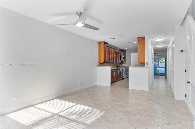 kitchen with tasteful backsplash, ceiling fan, light tile patterned flooring, and appliances with stainless steel finishes