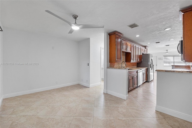 kitchen featuring light stone countertops, backsplash, stainless steel appliances, ceiling fan, and light tile patterned flooring