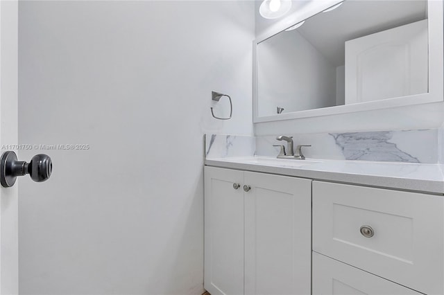 bathroom featuring vanity and tasteful backsplash