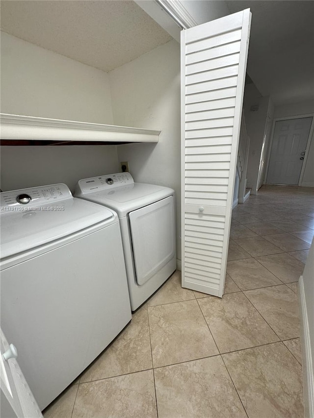 laundry room with light tile patterned flooring and washing machine and clothes dryer