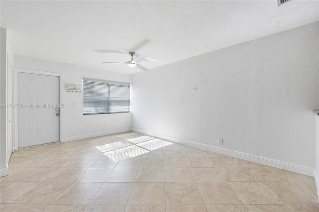 tiled empty room featuring ceiling fan