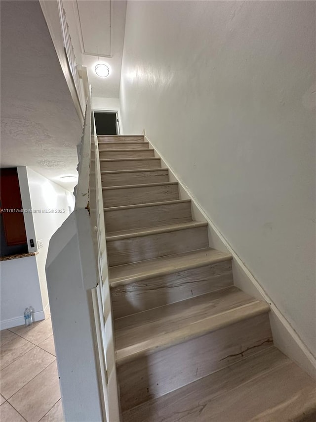 stairway with tile patterned floors