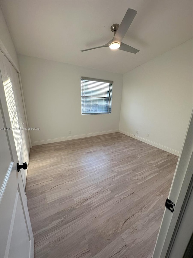 empty room with ceiling fan and light hardwood / wood-style floors