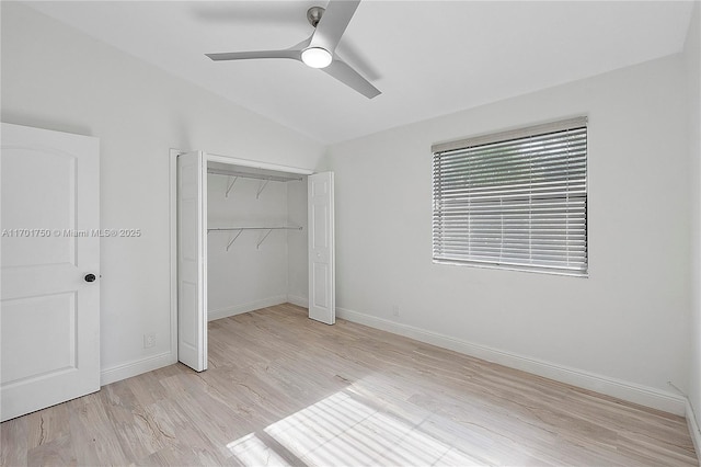 unfurnished bedroom featuring a closet, ceiling fan, light hardwood / wood-style flooring, and vaulted ceiling