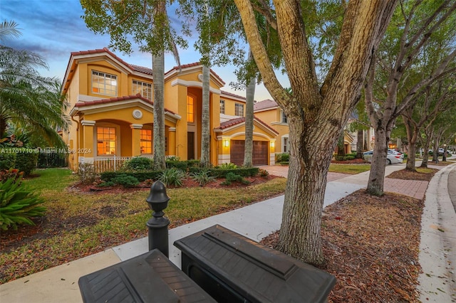 mediterranean / spanish-style house featuring a garage and a porch