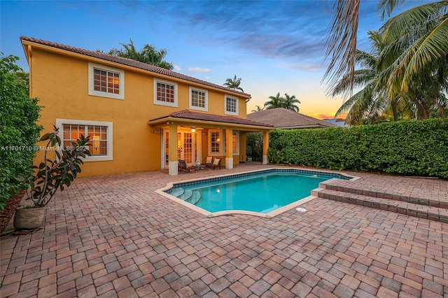 pool at dusk with a patio