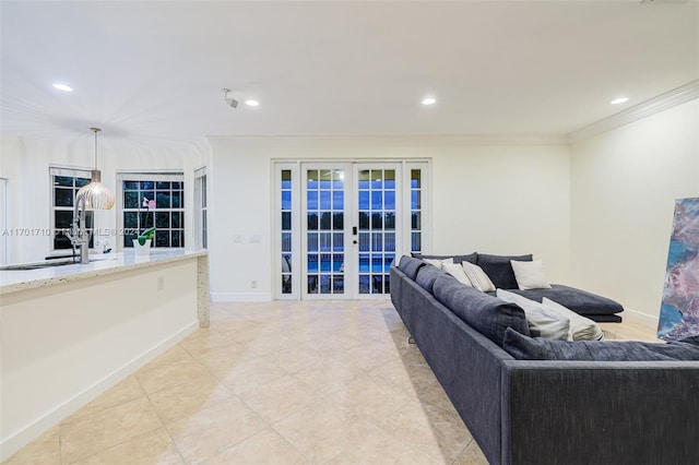 living room with light tile patterned floors, ornamental molding, french doors, and sink