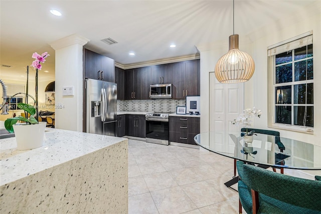 kitchen featuring stainless steel appliances, tasteful backsplash, dark brown cabinets, hanging light fixtures, and ornamental molding