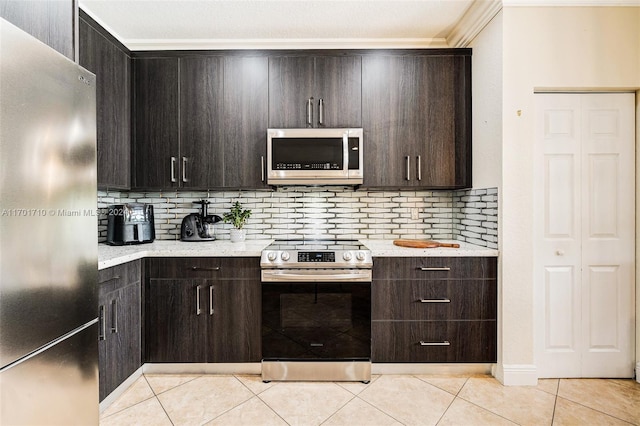 kitchen with light tile patterned floors, appliances with stainless steel finishes, dark brown cabinets, and tasteful backsplash