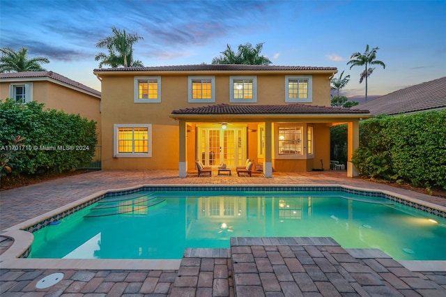 pool at dusk featuring a patio