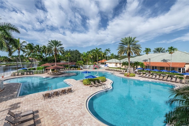 view of swimming pool featuring a water view and a patio area