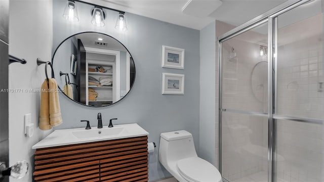 bathroom featuring an enclosed shower, vanity, and toilet