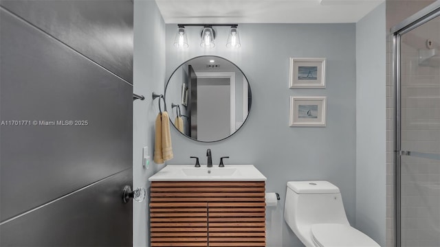 bathroom with vanity, toilet, and a shower with shower door