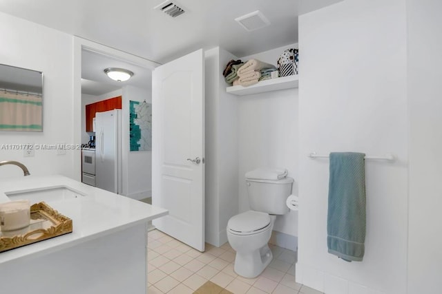 bathroom with tile patterned flooring, vanity, and toilet