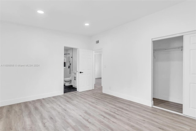 unfurnished bedroom featuring light wood-type flooring, a closet, and connected bathroom