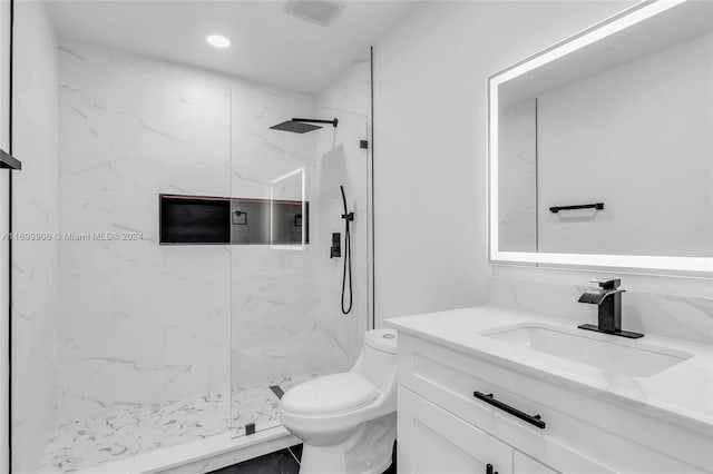 bathroom featuring vanity, toilet, and a tile shower