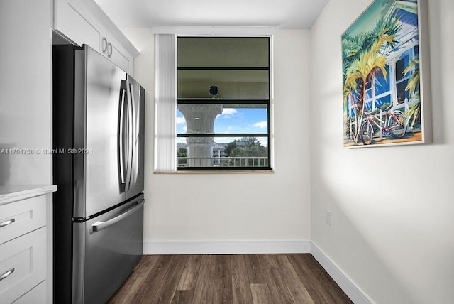 kitchen featuring stainless steel fridge, dark hardwood / wood-style floors, and white cabinetry