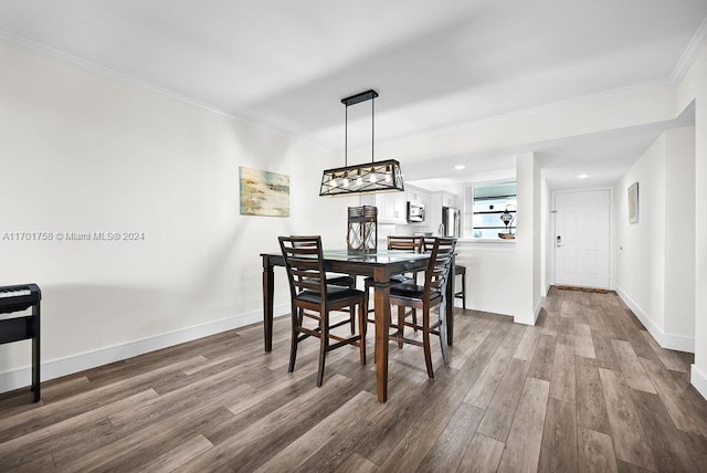 dining space featuring crown molding and hardwood / wood-style floors