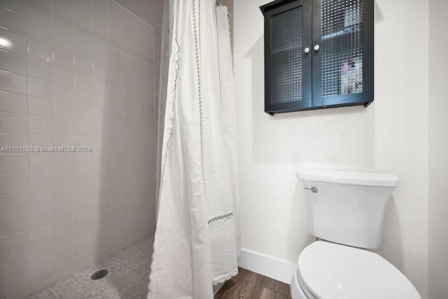 bathroom featuring toilet, wood-type flooring, and walk in shower