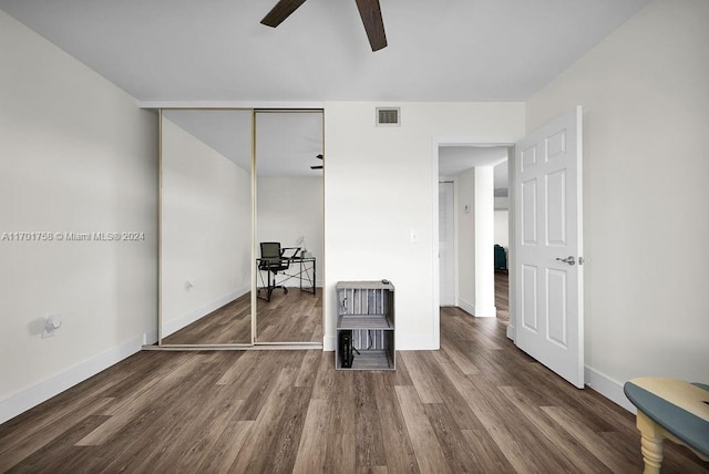 unfurnished bedroom featuring ceiling fan, a closet, and hardwood / wood-style flooring