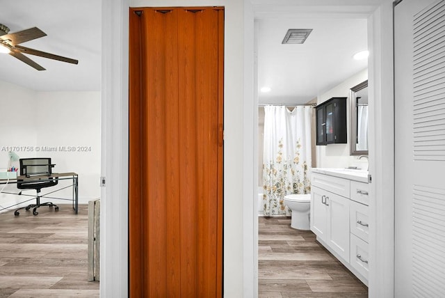 bathroom featuring ceiling fan, toilet, vanity, and hardwood / wood-style flooring