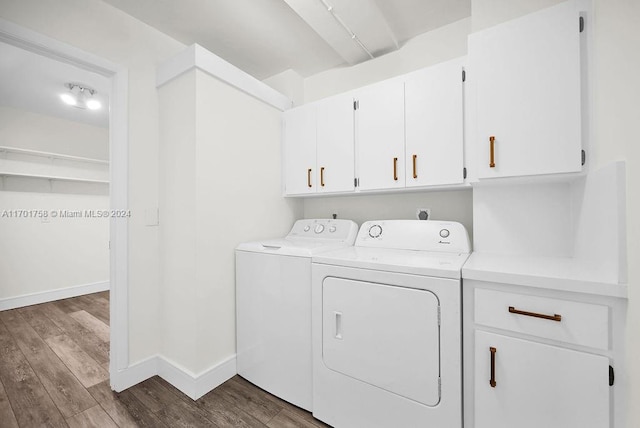 laundry room with hardwood / wood-style floors, washer and dryer, and cabinets