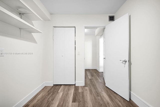 unfurnished bedroom featuring wood-type flooring and a closet