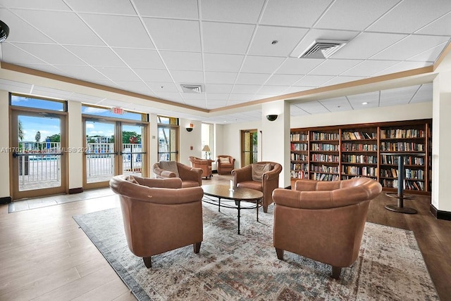 living room with a paneled ceiling, wood-type flooring, and french doors