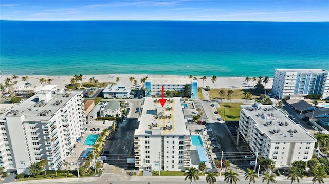 bird's eye view featuring a water view and a beach view