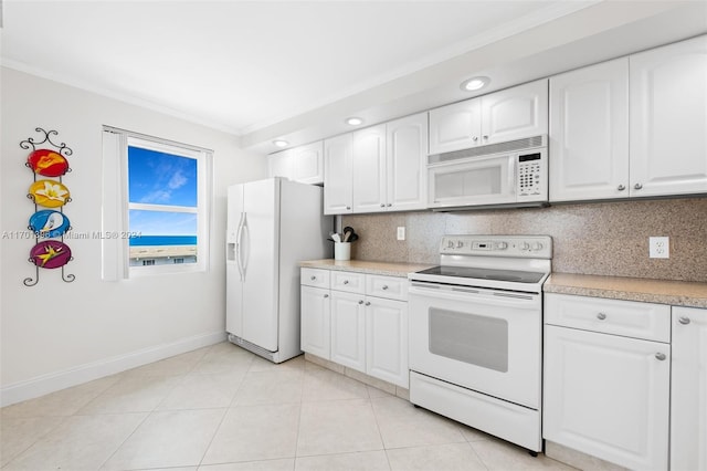 kitchen with white appliances, backsplash, white cabinets, ornamental molding, and light tile patterned flooring