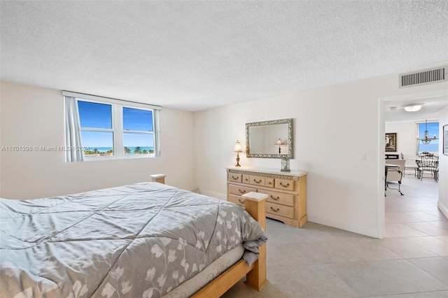 tiled bedroom featuring a textured ceiling