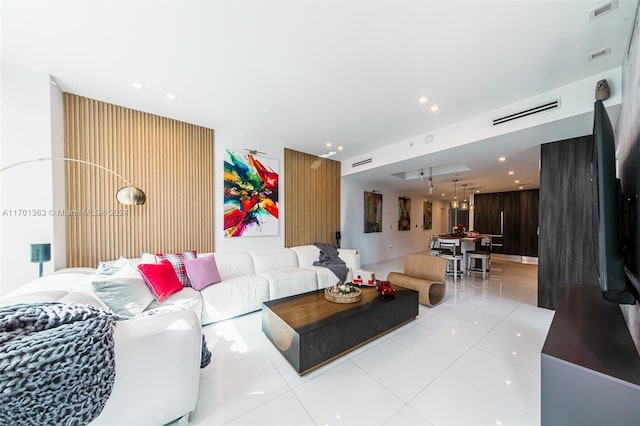 living room featuring wooden walls and light tile patterned floors