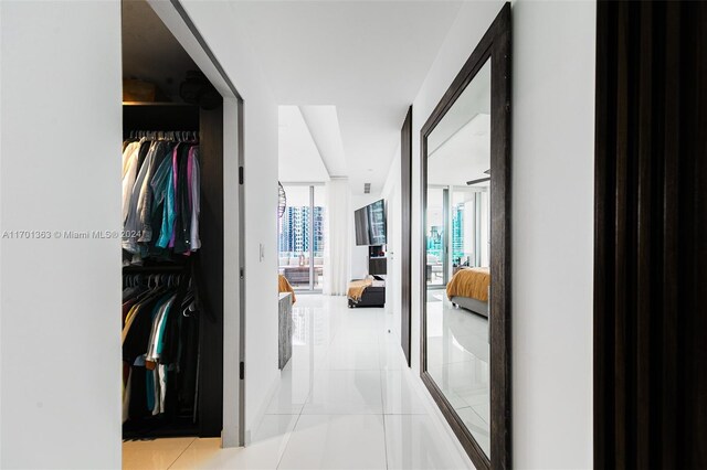 hallway featuring light tile patterned floors and expansive windows