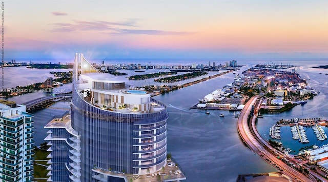 aerial view at dusk featuring a water view