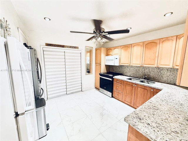 kitchen featuring light stone countertops, backsplash, white appliances, ceiling fan, and sink