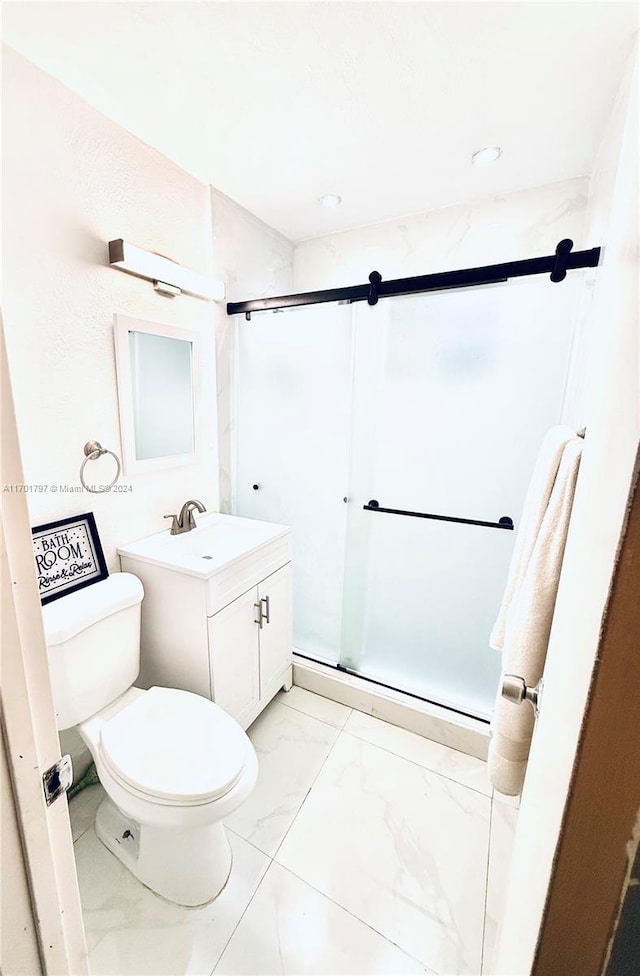 bathroom featuring vanity, toilet, and a shower with shower door