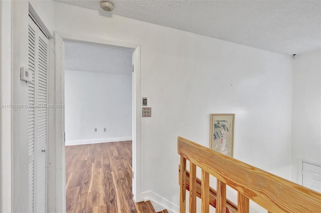 hallway featuring hardwood / wood-style floors and a textured ceiling